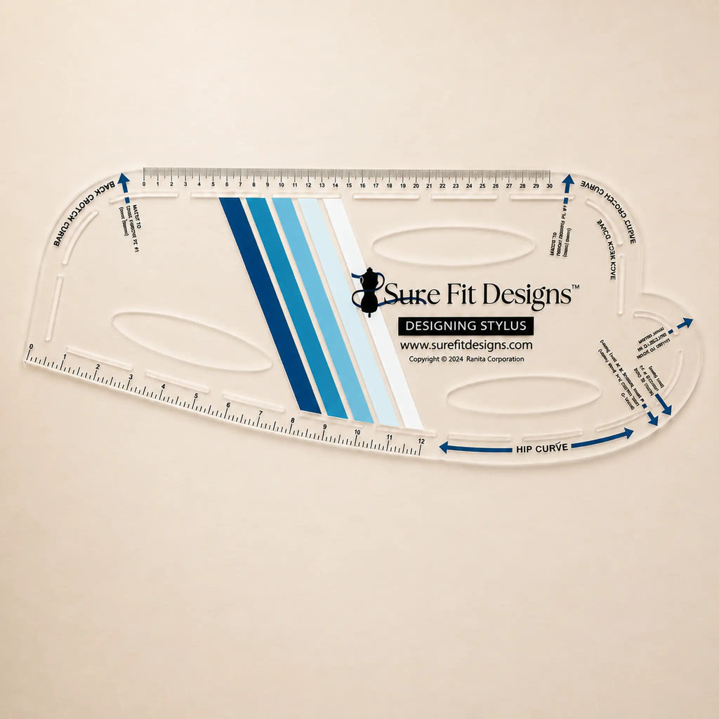 A clear acrylic quilting ruler with blue and white striped center design, featuring the Sure Fit Designs logo and brand website, displayed on a light beige background.
