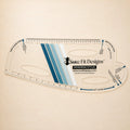 A clear acrylic quilting measuring tool labeled Sure Fit Designs Designing Stylus, shown on a warm beige background. The tool features blue and white striped accents and printed measurement markings.