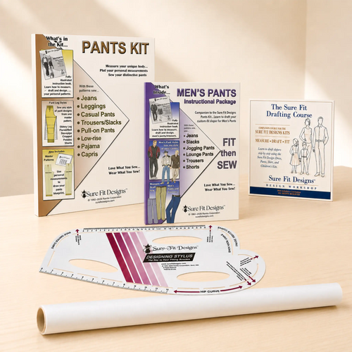Sure Fit Designs Pants Kit. Sewing pattern drafting and fitting kit displayed on a light wood surface with a beige background. Includes the pants, men's pants and drafting instruction booklets, a curved ruler, and a roll of tracing paper / vellum.