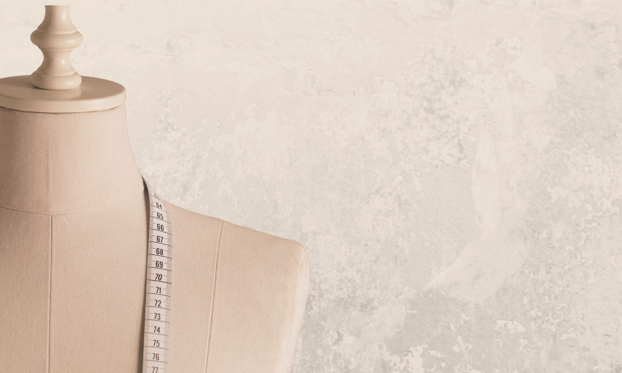 A beige wood and fabric dress form mannequin torso with a measuring tape draped over it, set against a textured light beige background.
